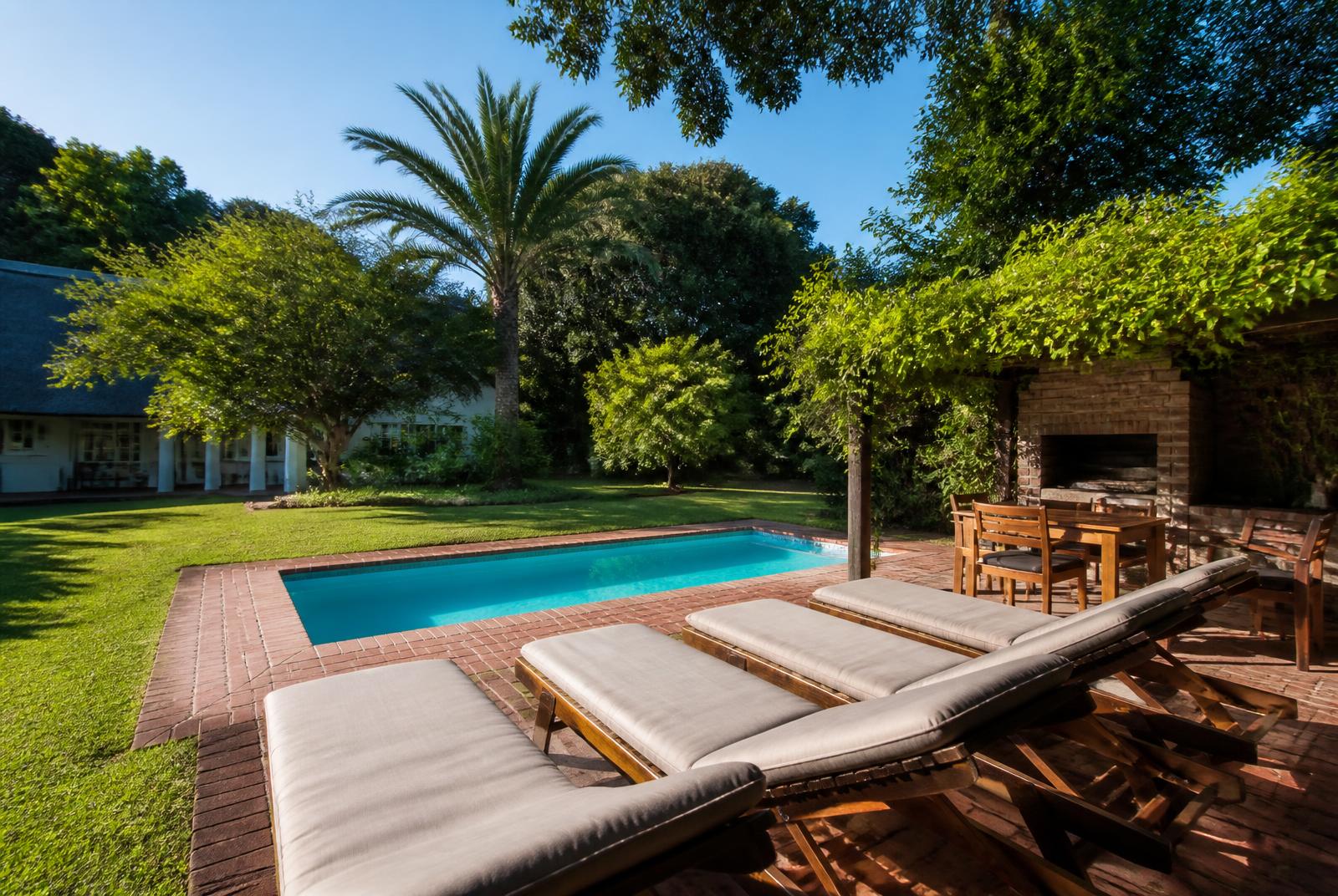 Outdoor pool, lawn and braai area in the garden at Epicure Home Guesthouse Heidelberg